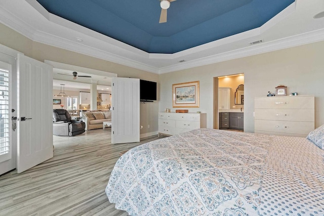 bedroom with light wood finished floors, visible vents, a raised ceiling, a ceiling fan, and ornamental molding