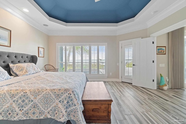 bedroom featuring wood finished floors, multiple windows, and a raised ceiling