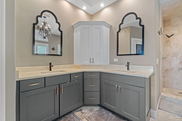 bathroom featuring a tile shower, double vanity, a sink, and recessed lighting