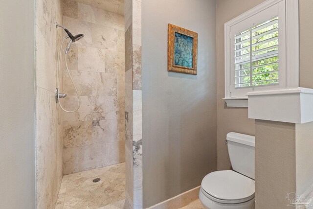 bathroom with toilet and tiled shower