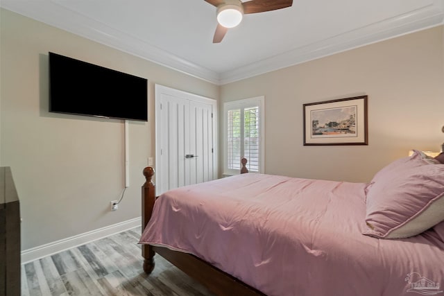 bedroom featuring crown molding, a closet, ceiling fan, wood finished floors, and baseboards