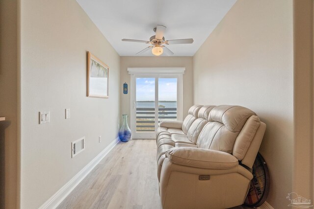 living area featuring a ceiling fan, visible vents, light wood-style flooring, and baseboards