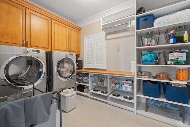 laundry room with independent washer and dryer and cabinet space