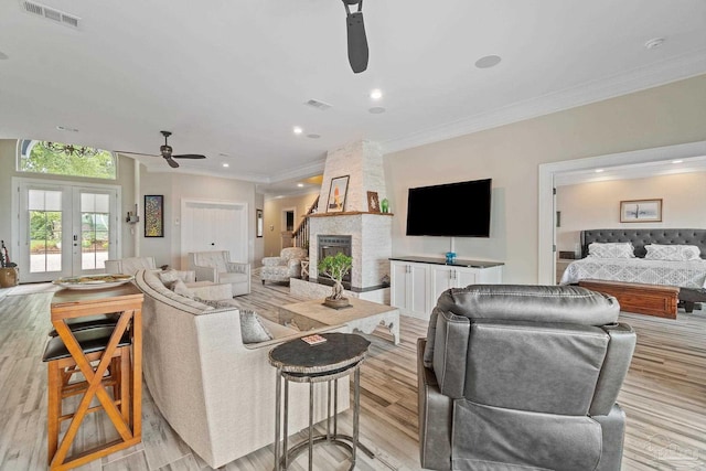 living area with french doors, light wood-style flooring, visible vents, and a ceiling fan