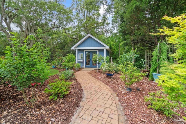 view of front of house featuring french doors and an outbuilding