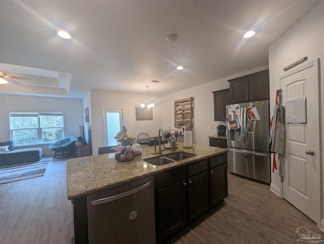 kitchen with dark wood-style floors, appliances with stainless steel finishes, an island with sink, and a sink