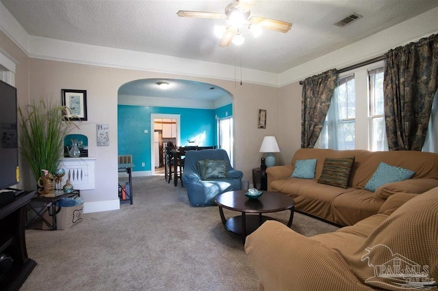 carpeted living room featuring a textured ceiling and ceiling fan