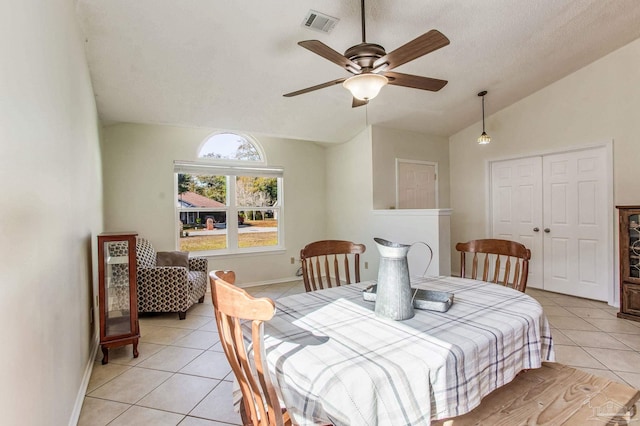 tiled dining room featuring lofted ceiling and ceiling fan