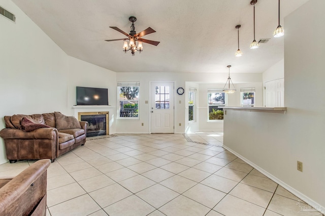 living room featuring ceiling fan, light tile patterned floors, and vaulted ceiling