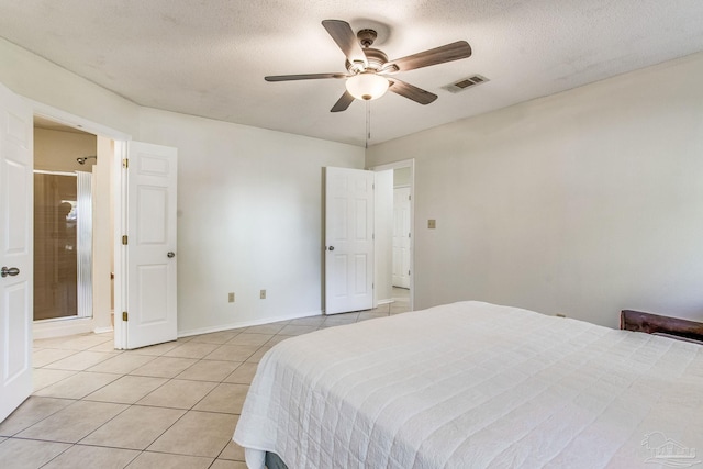 bedroom with a textured ceiling, ceiling fan, and light tile patterned flooring