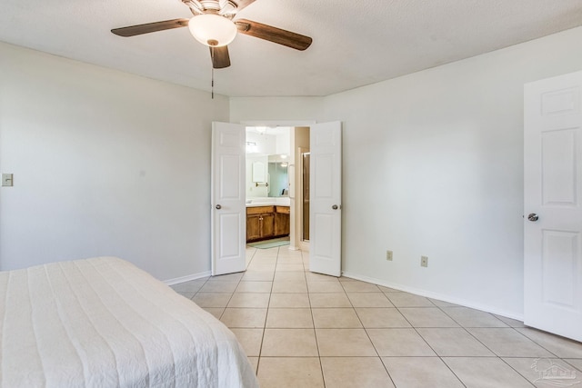 tiled bedroom featuring ceiling fan, a textured ceiling, and ensuite bath