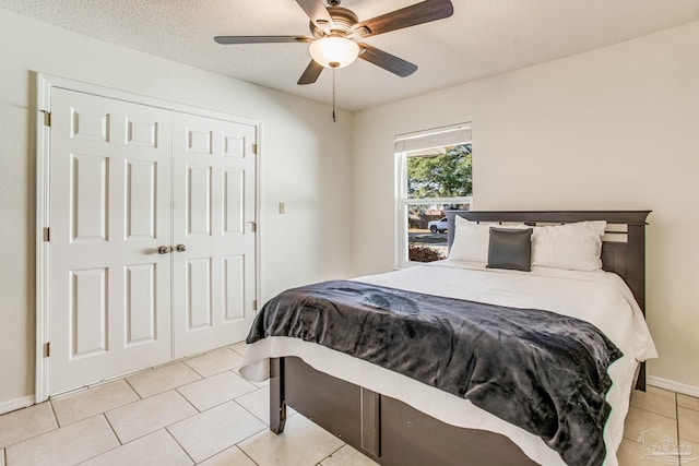 tiled bedroom featuring ceiling fan, a textured ceiling, and a closet