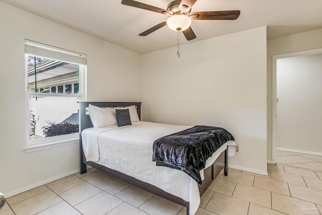 tiled bedroom featuring ceiling fan