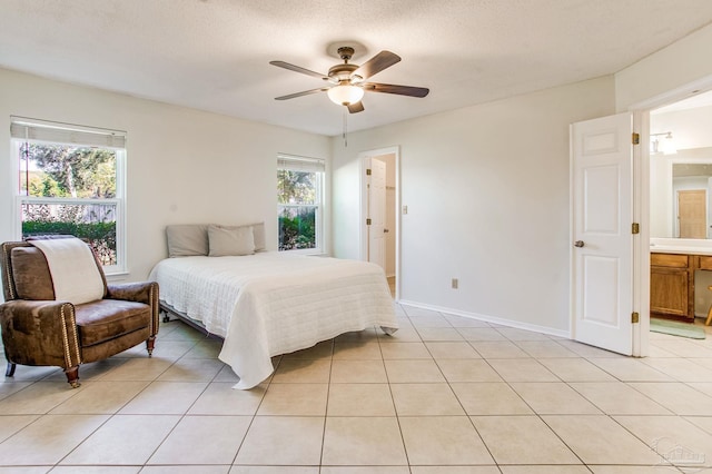 bedroom featuring a textured ceiling, ceiling fan, light tile patterned flooring, and ensuite bath