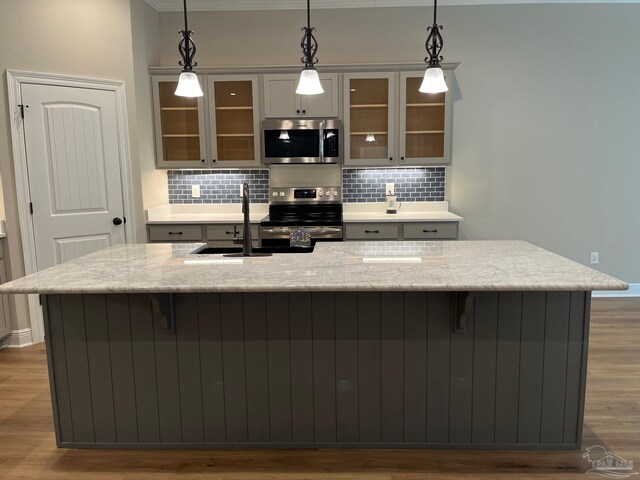 bar with hanging light fixtures, stainless steel appliances, and tasteful backsplash