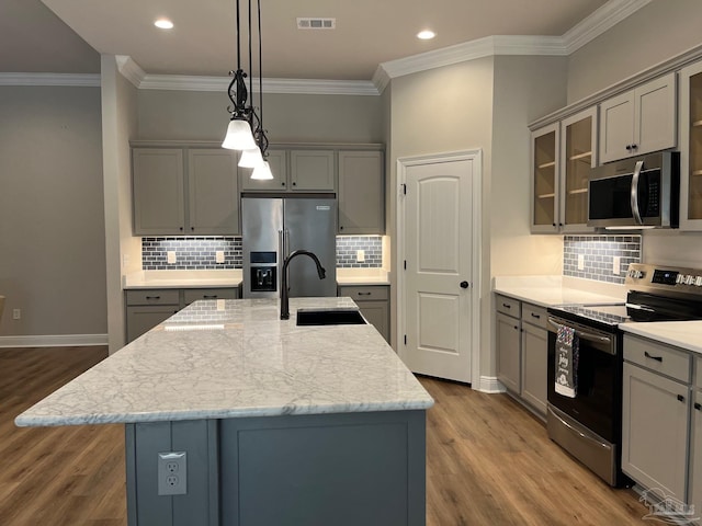 kitchen with sink, stainless steel appliances, a center island with sink, and wood-type flooring