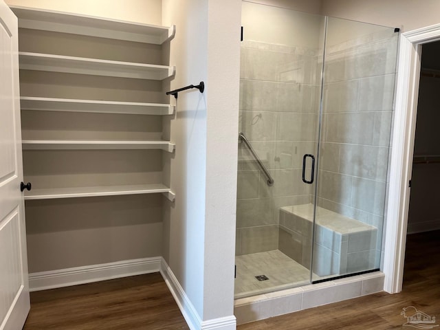 bathroom with hardwood / wood-style flooring and a shower with door