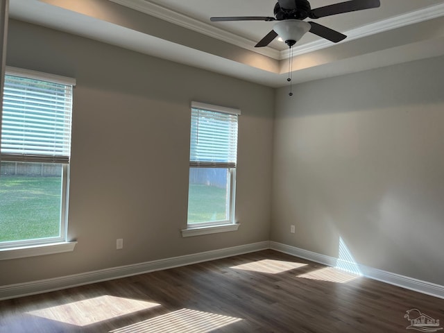 empty room with dark hardwood / wood-style floors, plenty of natural light, crown molding, and ceiling fan