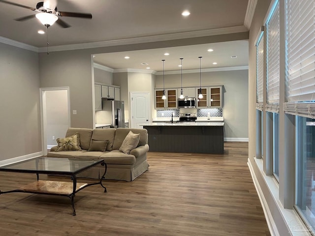 living room featuring crown molding, ceiling fan, dark wood-type flooring, and sink