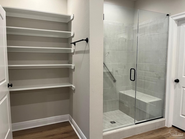 bathroom featuring wood-type flooring and a shower with door