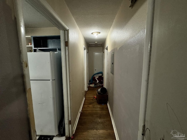 hallway with dark hardwood / wood-style floors and a textured ceiling