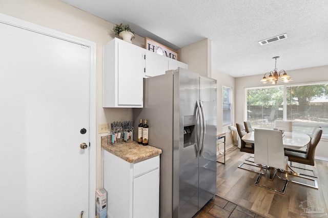 4701 Kitty Hawk Cir, Gulf Breeze, FL 32563 - kitchen featuring stainless steel fridge with ice dispenser, a chandelier, white cabinets, a textured ceiling, and hanging light fixtures