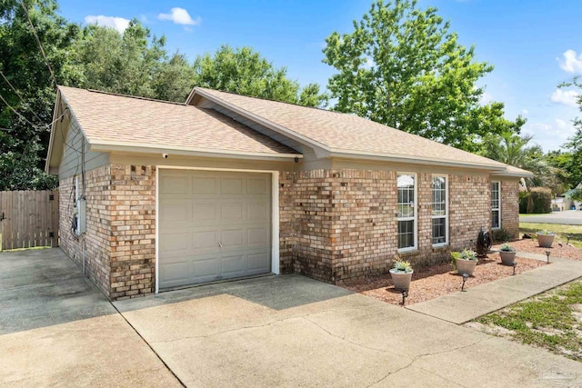 4701 Kitty Hawk Cir, Gulf Breeze, FL 32563 - ranch-style house featuring concrete driveway, roof with shingles, an attached garage, and brick siding
