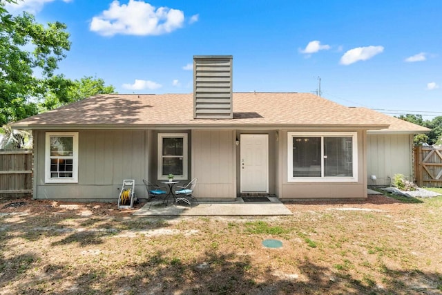 4701 Kitty Hawk Cir, Gulf Breeze, FL 32563 - back of house featuring a chimney, a shingled roof, and a patio