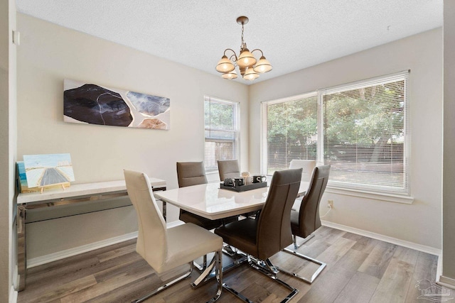 4701 Kitty Hawk Cir, Gulf Breeze, FL 32563 - dining space with a chandelier, light wood finished floors, baseboards, and a textured ceiling