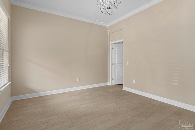 spare room with ornamental molding, light hardwood / wood-style flooring, and a chandelier