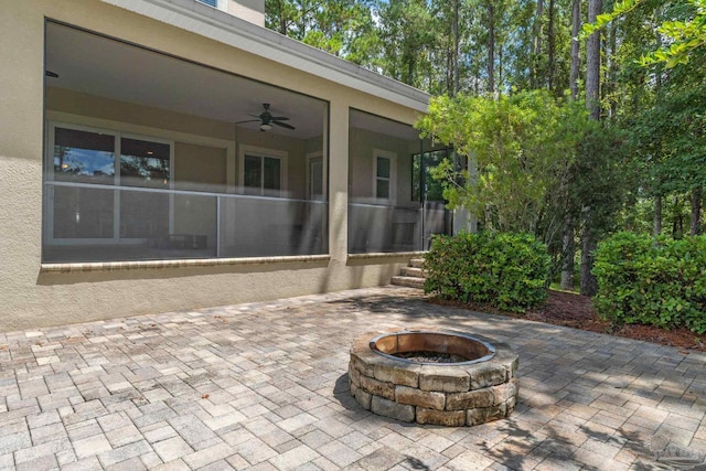 view of patio / terrace with a fire pit and ceiling fan