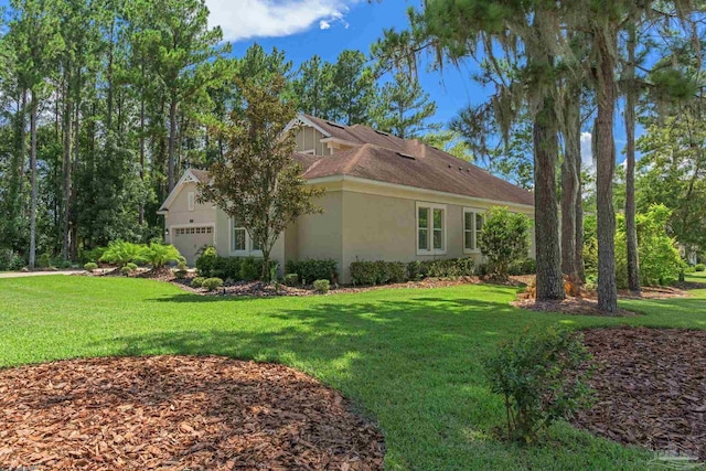 view of side of property featuring a garage and a yard