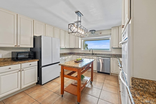 2950 Coral Strip Pkwy, Gulf Breeze, FL 32563 - kitchen featuring dishwasher, freestanding refrigerator, black microwave, a sink, and light tile patterned flooring