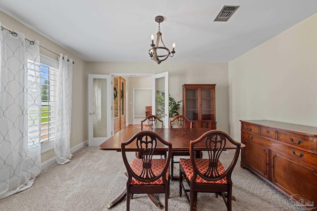 2950 Coral Strip Pkwy, Gulf Breeze, FL 32563 - dining area featuring a chandelier, light colored carpet, french doors, and baseboards