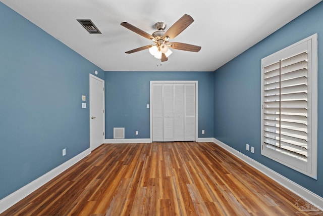 2950 Coral Strip Pkwy, Gulf Breeze, FL 32563 - unfurnished bedroom featuring wood finished floors, baseboards, a closet, and a ceiling fan