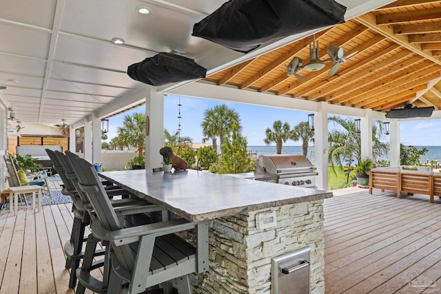 2950 Coral Strip Pkwy, Gulf Breeze, FL 32563 - wooden deck with area for grilling, an outdoor kitchen, a water view, and ceiling fan