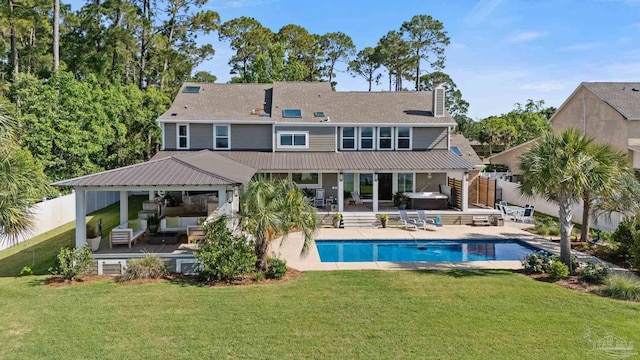 2950 Coral Strip Pkwy, Gulf Breeze, FL 32563 - rear view of house with an outdoor living space, a chimney, a patio area, a hot tub, and metal roof