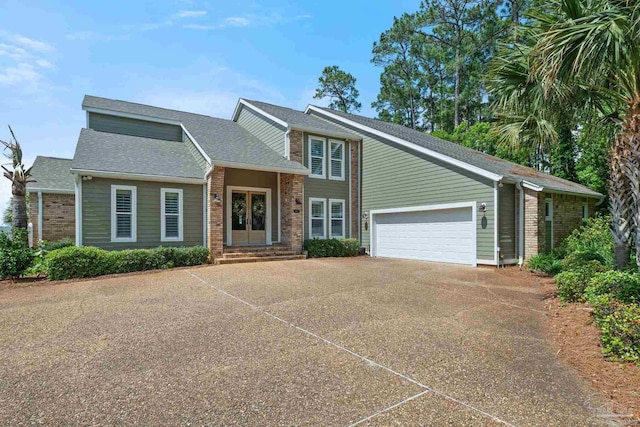 2950 Coral Strip Pkwy, Gulf Breeze, FL 32563 - view of front facade with brick siding, concrete driveway, an attached garage, and roof with shingles