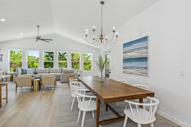 dining area with vaulted ceiling, ceiling fan with notable chandelier, and light hardwood / wood-style floors