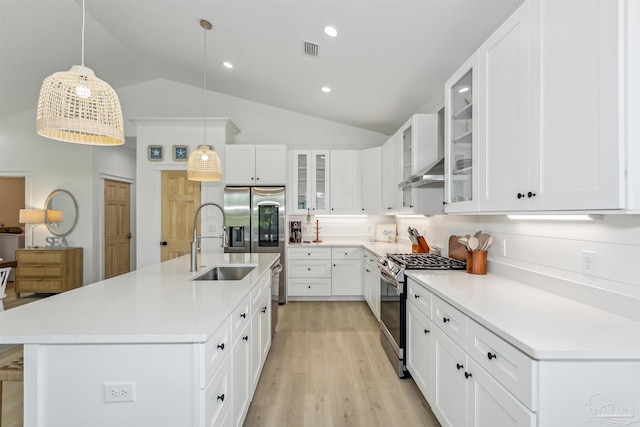 kitchen with white cabinetry, appliances with stainless steel finishes, decorative light fixtures, and a center island with sink