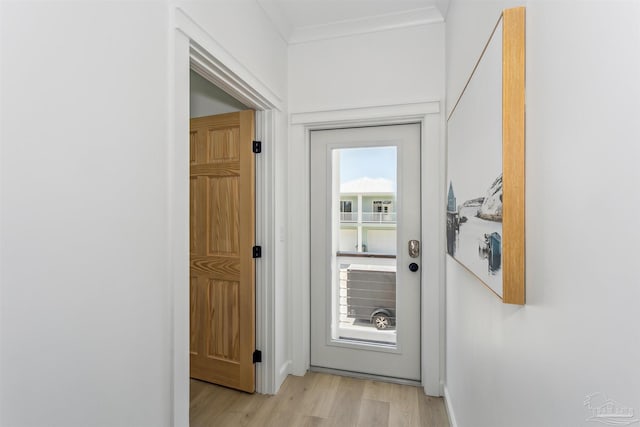 doorway to outside featuring ornamental molding and light hardwood / wood-style flooring