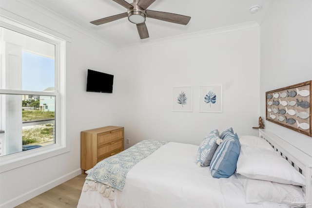 bedroom featuring ceiling fan, ornamental molding, and light hardwood / wood-style flooring