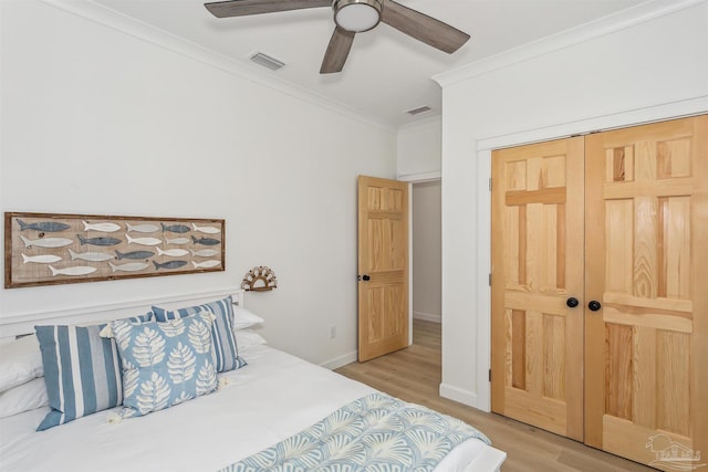 bedroom with crown molding, light hardwood / wood-style flooring, a closet, and ceiling fan