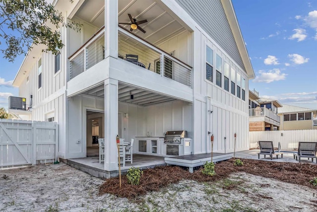 rear view of property with exterior kitchen, ceiling fan, central air condition unit, and a patio area