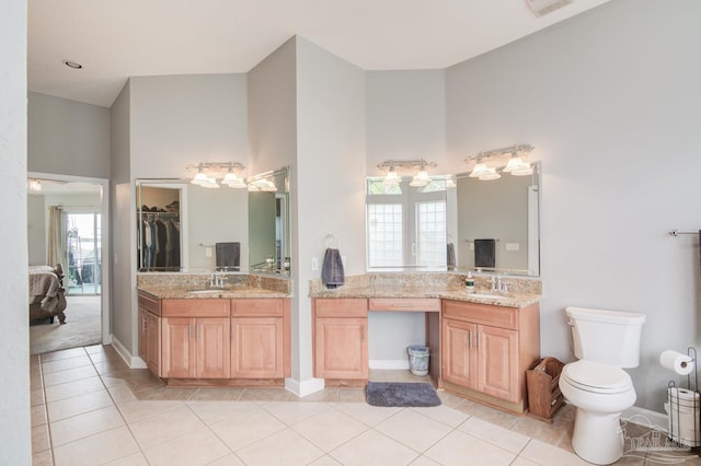 bathroom with a high ceiling, a wealth of natural light, and toilet