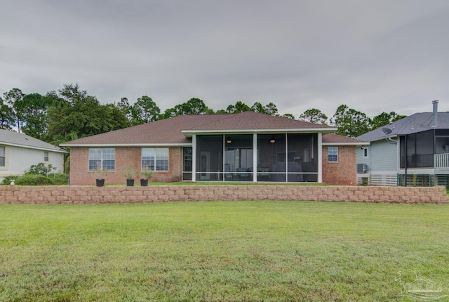 back of property with a sunroom and a yard