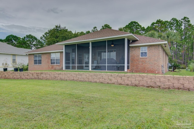 back of house featuring a lawn and a sunroom