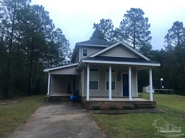 view of front of property featuring a front lawn, covered porch, and a trampoline