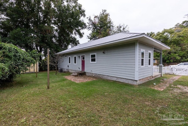 back of property featuring central AC and a yard