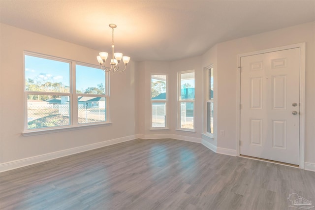 foyer entrance featuring hardwood / wood-style flooring, a chandelier, and a wealth of natural light